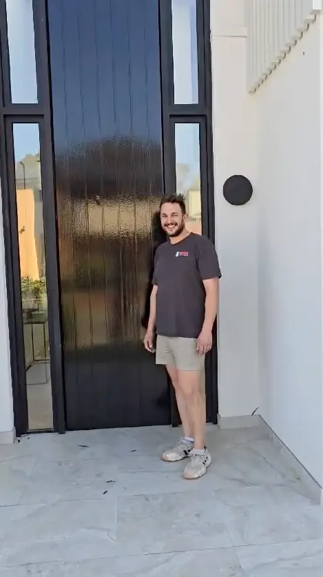 Owner standing in front of a stylish custom project at completion.